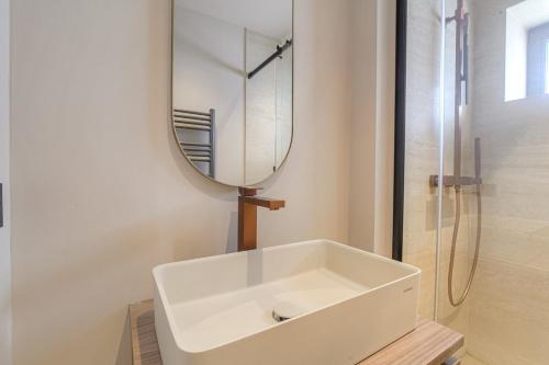a bathroom with a white sink and a mirror at Studio lumineux avec terrasse, à deux pas de Lyon in Écully