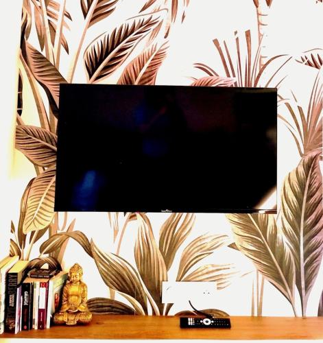 un téléviseur à écran plat posé sur une table dans l'établissement Tribord Holiday House, à Nice
