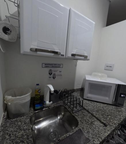a kitchen counter with a sink and a microwave at HAUSHostel in Vinhedo