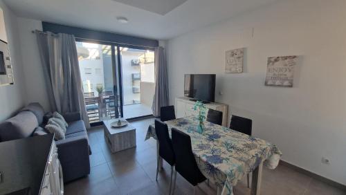 un soggiorno con un tavolo e un divano di Edificio Calpe Beach Arenal a Calpe