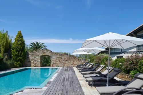 a pool with chairs and umbrellas next to a building at Villa Askizu by FeelFree Rentals in Getaria