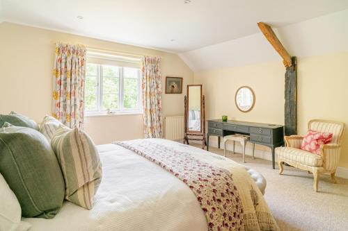 sypialnia z łóżkiem, biurkiem i oknem w obiekcie Poppys Cottage w mieście Newton Saint Cyres