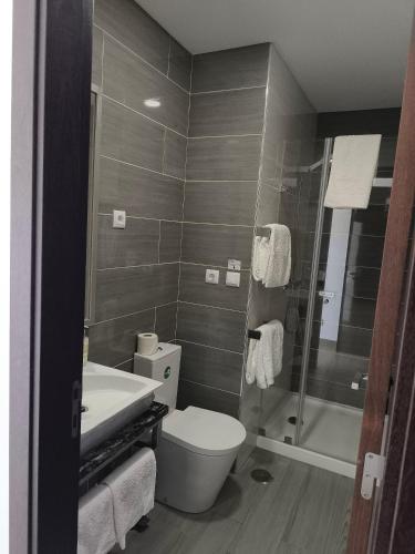 a bathroom with a toilet and a sink and a shower at Baleal 4 Surf in Baleal