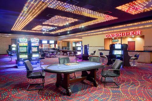 a casino with several slot machines and a table and chairs at Catalonia Punta Cana - All Inclusive in Punta Cana