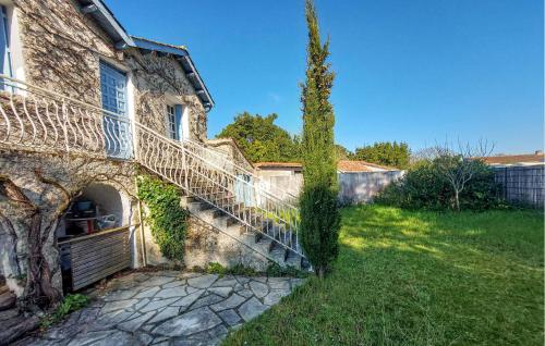 un bâtiment couvert de lierre avec un escalier à côté d'un arbre dans l'établissement 3 Bedroom Stunning Home In Le Château-Doléron, au Château-dʼOléron
