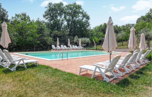 a pool with lounge chairs and umbrellas next to it at Stunning Home In Spoleto in Spoleto