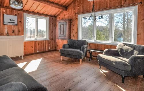 a living room with chairs and a table and windows at Beautiful Home In Årjäng With Lake View in Årjäng