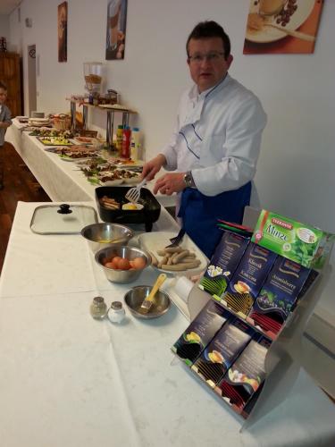 a man standing in front of a table preparing food at Landhotel Solmser Hof GbR in Echzell