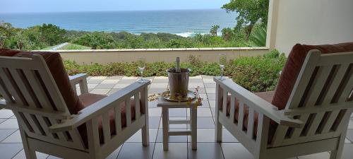 two chairs on a patio with a view of the ocean at Ocean Grove Guesthouse in Port Edward