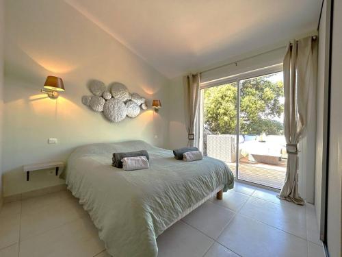 une chambre avec un lit et une grande fenêtre dans l'établissement Villa 3 chambres dans résidence avec piscine, à Porto-Vecchio