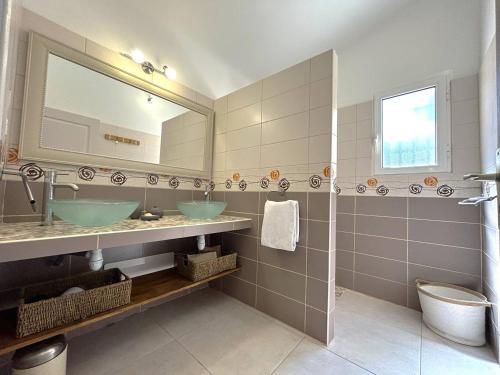 une salle de bain avec deux lavabos et un miroir dans l'établissement Villa 3 chambres dans résidence avec piscine, à Porto-Vecchio