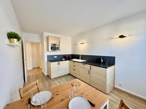 une cuisine avec une table en bois et une salle à manger dans l'établissement Vesle & Vignes au Cœur de Reims, à Reims