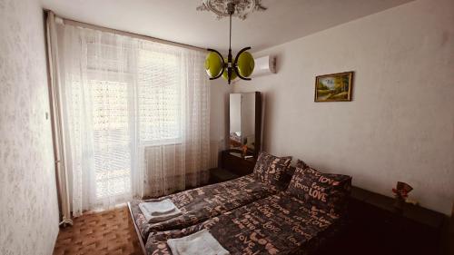 a bedroom with a bed and a large window at Апартамент Димови in Tryavna