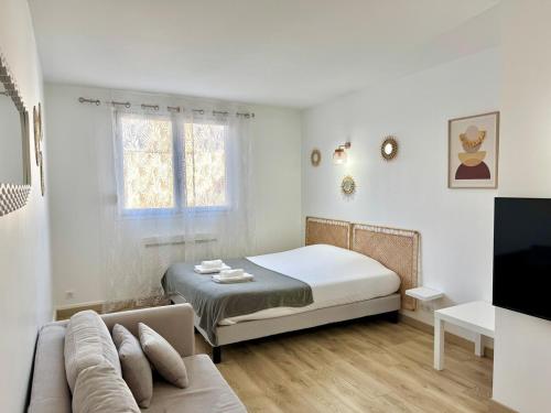 - une chambre blanche avec un lit et un canapé dans l'établissement Vesle & Vignes au Cœur de Reims, à Reims