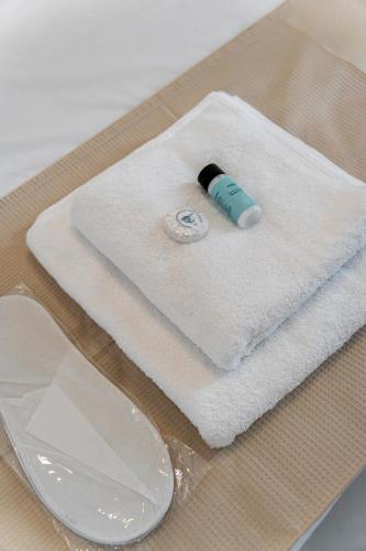 a bottle on a white towel on a table at Howard Luxury APT in Agios Nikolaos