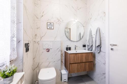 a bathroom with a toilet and a sink and a mirror at Casa Blue Moon in Baveno