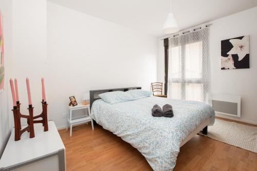- une chambre dotée d'un lit avec une paire de chaussures dans l'établissement T2 cosy à 2 pas de la Garonne - Parking privé, à Toulouse