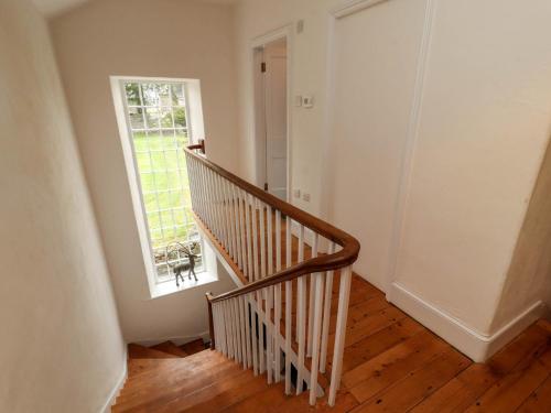 an empty hallway with a staircase and a window at 1 The Green in Carnforth