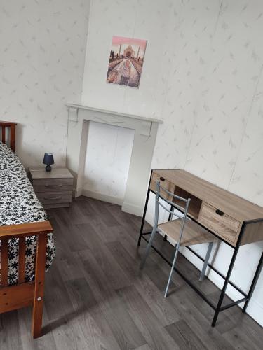 - une chambre avec un bureau, un lit et une table dans l'établissement Gîte des Vieilles Forges, à Fromelennes