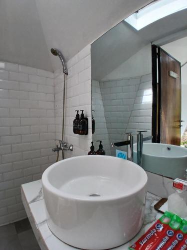 a bathroom with a large white tub and a sink at Grace Hill Villa Lubuk Minturun in Padang