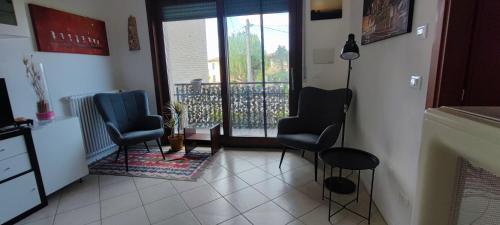 a living room with two chairs and a balcony at Appartamento Via San Vitale in Tabellini