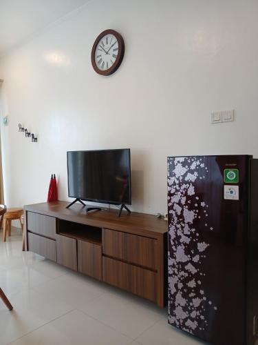 a living room with a tv and a refrigerator at Grace Hill Villa Lubuk Minturun in Padang