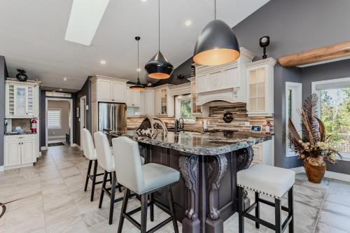 a kitchen with a large island with bar stools at 45 Degrees North - Tobermory in Tobermory