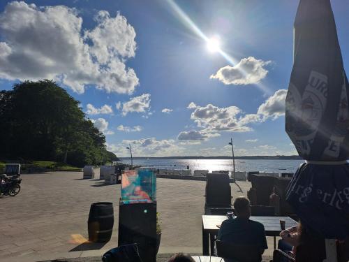 a group of people sitting at tables by the water at Ferienhaus Küstenbrise in Holnishof