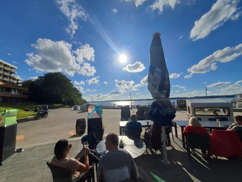 a group of people sitting around a table with a surfboard at Ferienhaus Küstenbrise in Holnishof