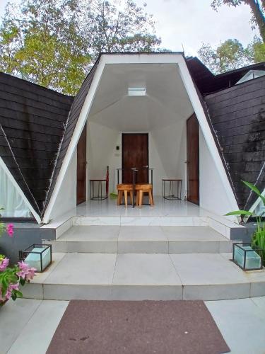 a patio with a table and chairs in a house at Grace Hill Villa Lubuk Minturun in Padang