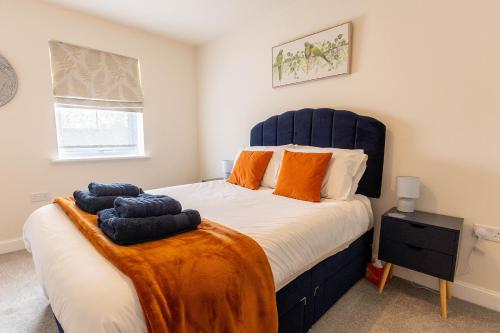 a bedroom with a large bed with orange pillows at APPLECROFT - Escape to the Peak District National Park in Buxton