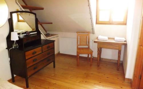 a room with a dresser and a mirror and a desk at Taigh Aonghais in Tarskavaig