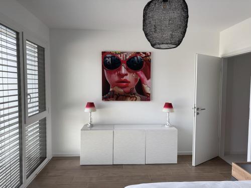 a room with a painting of a woman with sunglasses at Appartement de standing T3 - Lina in Hésingue