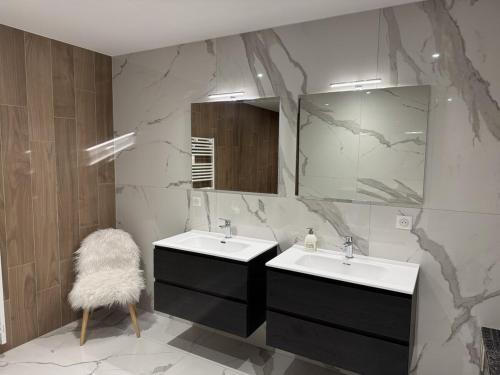 une salle de bain avec deux lavabos et un miroir dans l'établissement Appartement de standing T3 - Lina, à Hésingue