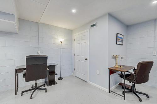a room with a desk and two chairs and a door at Piccadilly Fields Escape in Traverse City