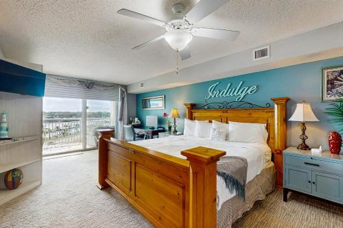 a bedroom with a large bed with a wooden headboard at Yacht Club Villas 1-501 in Myrtle Beach