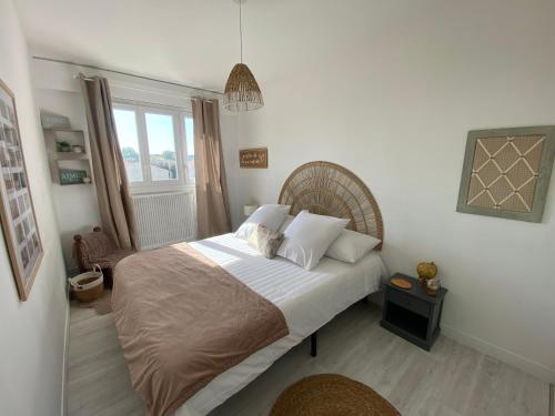 une chambre avec un grand lit et une fenêtre dans l'établissement Le Rochefort, à Les Sables-dʼOlonne