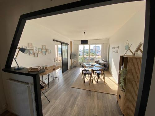 une salle à manger et un salon avec une table et des chaises dans l'établissement Le Rochefort, à Les Sables-dʼOlonne