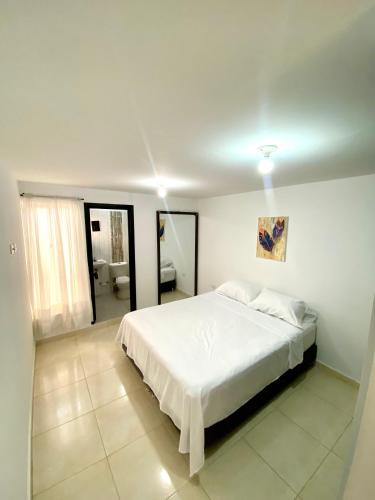 a bedroom with a white bed and a bathroom at Casa en la capital turística de Santander in San Gil