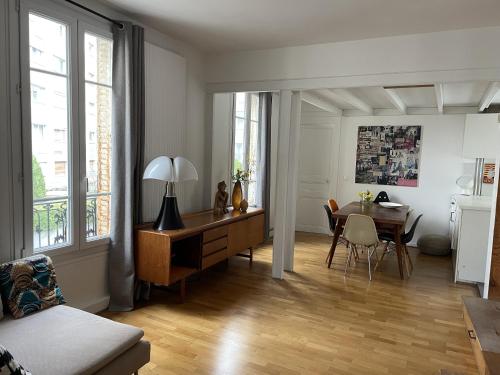 - un salon avec un bureau et une table à manger dans l'établissement Duplex - Butte aux Cailles, à Paris