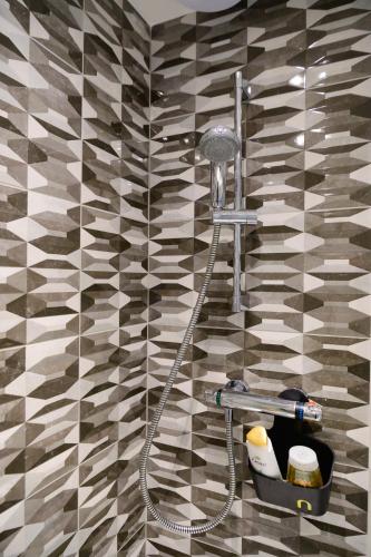 a shower in a bathroom with a tiled wall at Located in the peaceful NG8 Wollaton , Perfect for Business Trips & Family Holidays or working proffesionals-long term deals, M1 Nearby , Free Parking , Private Garden , 500Mb Wi-Fi , Netflix in Nottingham