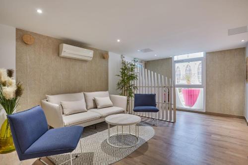 a living room with a couch and two blue chairs at Résidence Odalys Les Dunes du Soleil in La Grande-Motte