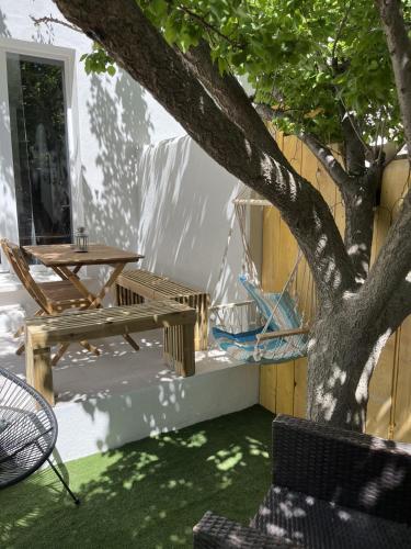 a patio with a picnic table and a tree at L Abri-côtier Appartements in Saintes-Maries-de-la-Mer