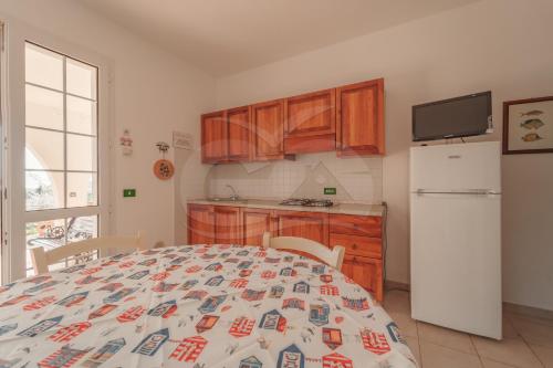 a kitchen with a bed and a white refrigerator at La Palazzina nel Verde - Goelba in Campo nell'Elba