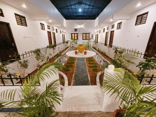 a room with a table and chairs and plants at Hare Rama Hare Krishna - EESHA Hotel in Rāmeswaram