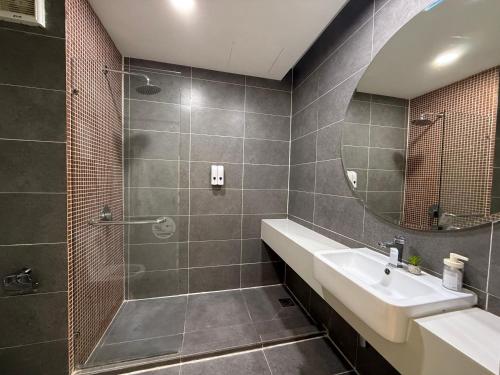 a bathroom with a shower and a sink and a mirror at Empire Damansara Cozy Hotel Room in Petaling Jaya