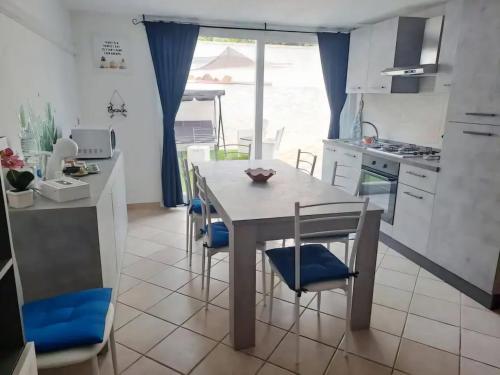 a kitchen with a table and chairs in a kitchen at Summer House in SantʼAntìoco