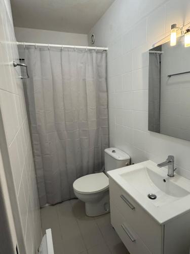 une salle de bain blanche avec des toilettes et un lavabo dans l'établissement Appartement cosy avec terrasse, à Vallauris
