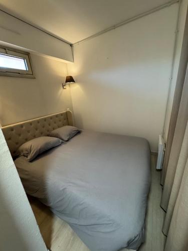 un lit dans une petite pièce avec une fenêtre dans l'établissement Appartement cosy avec terrasse, à Vallauris