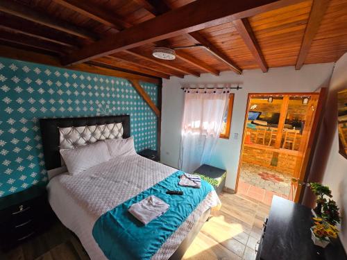 a bedroom with a large bed with blue and white at Hostal la Divisa Salento in Arrayanal